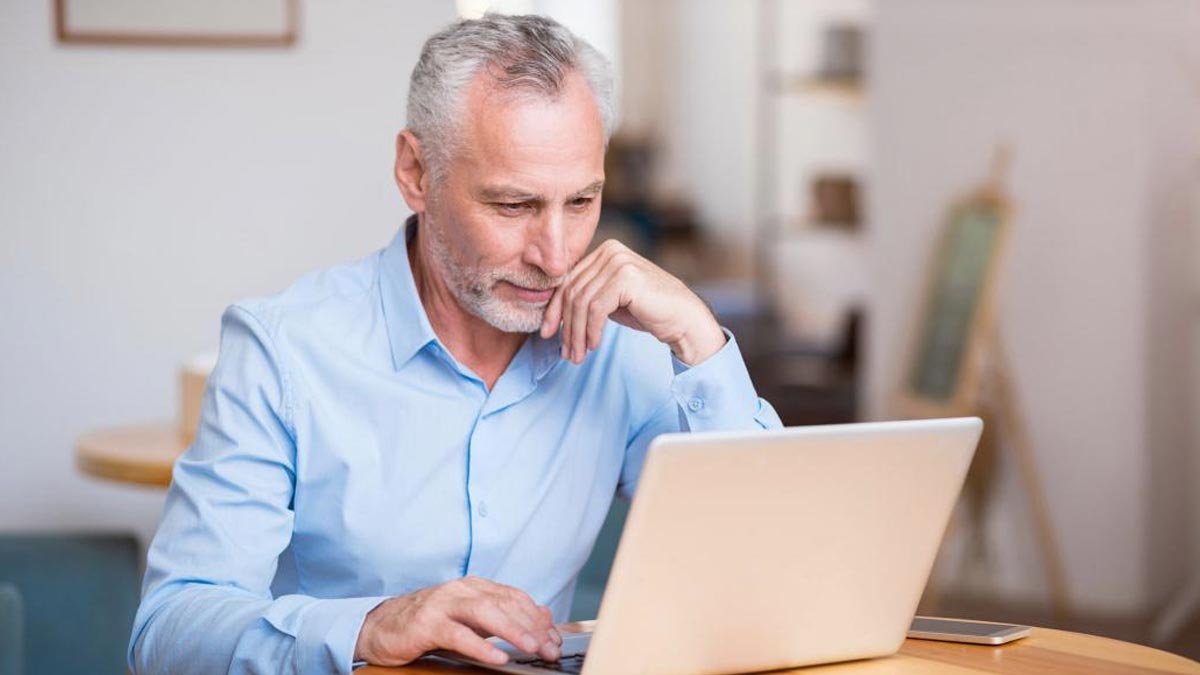 Persona mayor viendo una laptop.