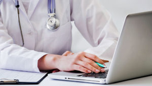 Doctor mirando un expediente en su laptop