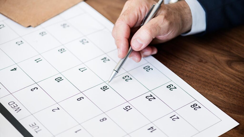 Una persona indicando la fecha en el calendario