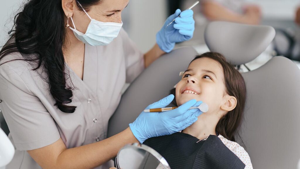 Odontóloga atendiendo a una niña